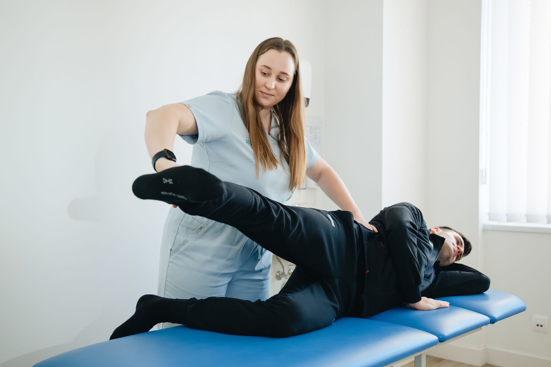 Physiothérapeute travaillant sur la jambe d'un patient en cabinet