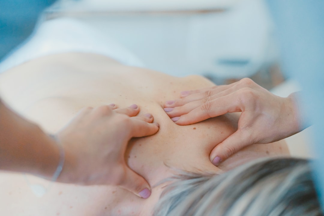 Physiothérapeute massant le dos d'une patiente