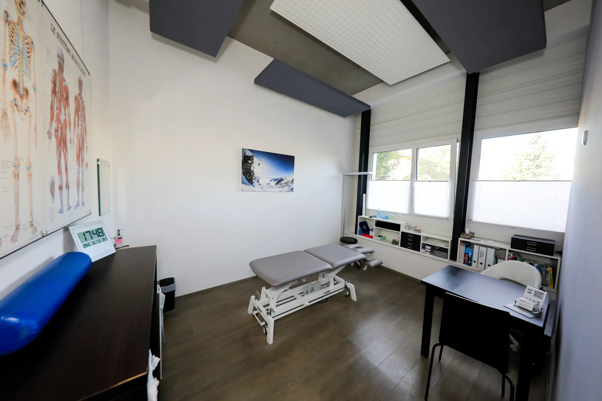 Cabinet de physiothérapie du centre VO2Sport avec table de soin, bureau et affiches anatomiques