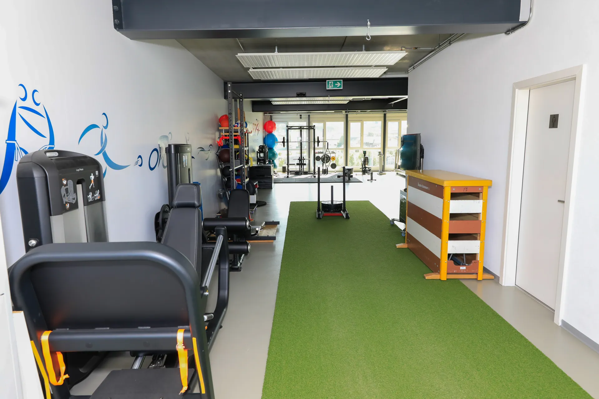 Espace de musculation du centre VO2Sport avec appareils de fitness et piste en gazon synthétique pour les sprints