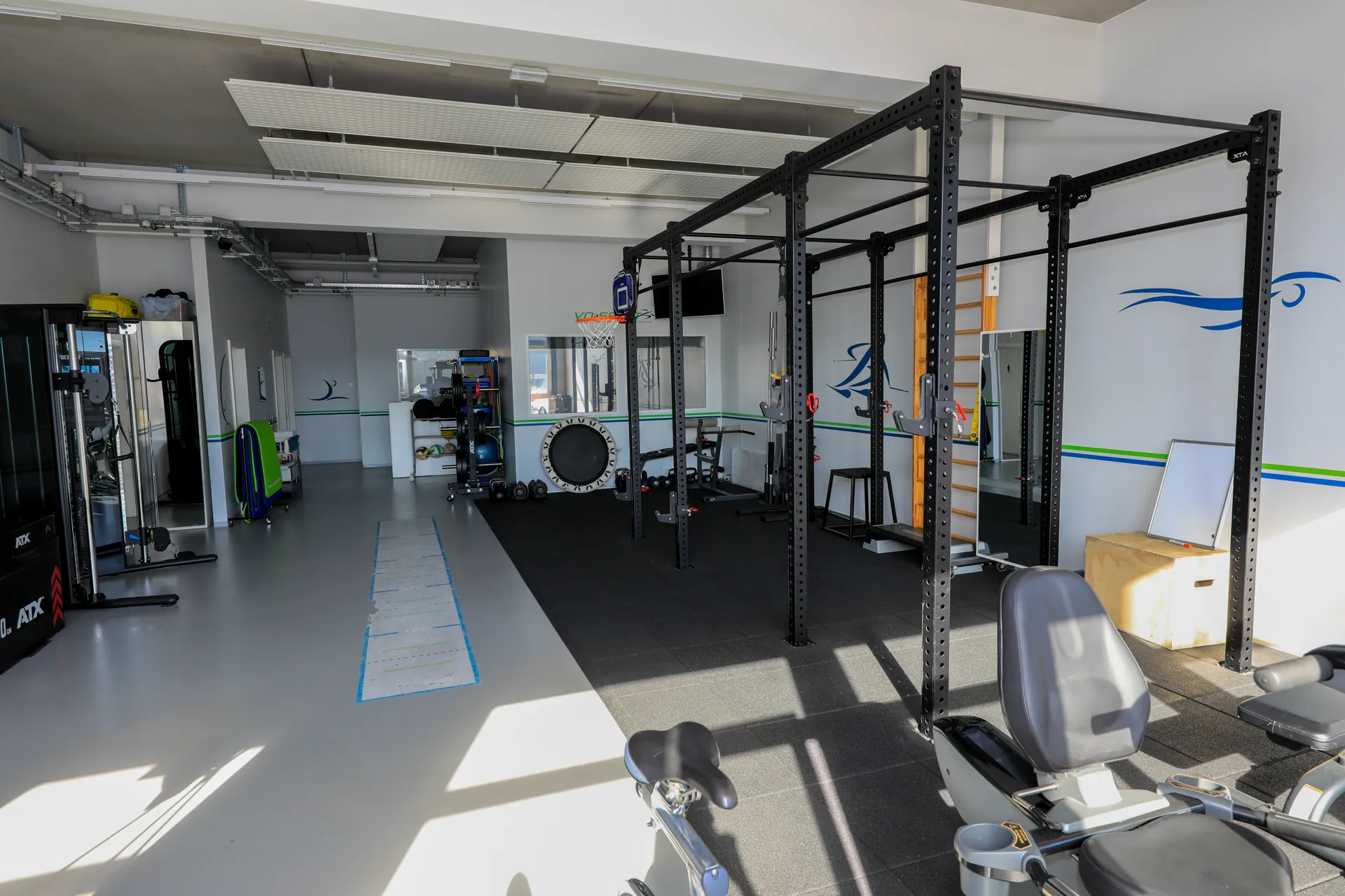 Salle de réathlétisation du centre VO2Sport avec cages de musculation, vélos et équipements d’entraînement