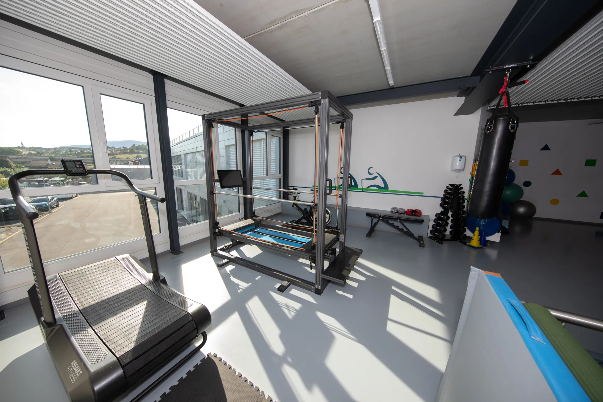Salle d’entraînement du centre VO2Sport avec reformer Pilates, tapis de course et sac de frappe